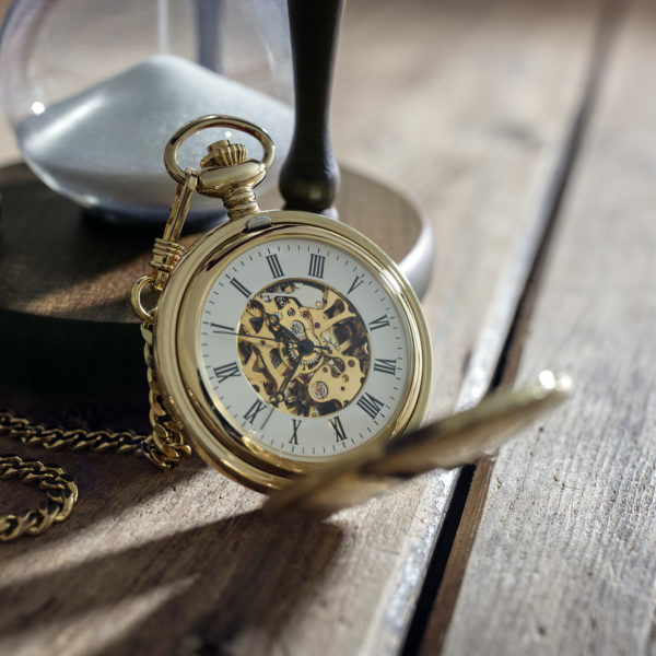 A gold pocket watch and an hourglass